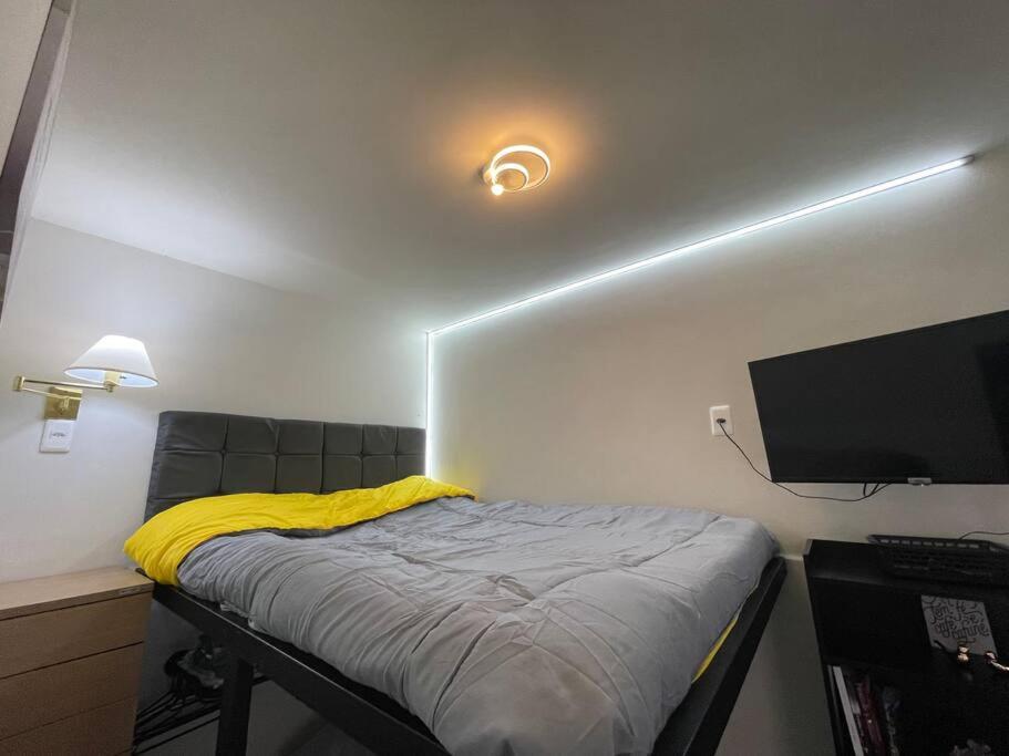 En eller flere senge i et værelse på Confortável loft 4,ar, Wi-Fi, TV, 400m UNIG