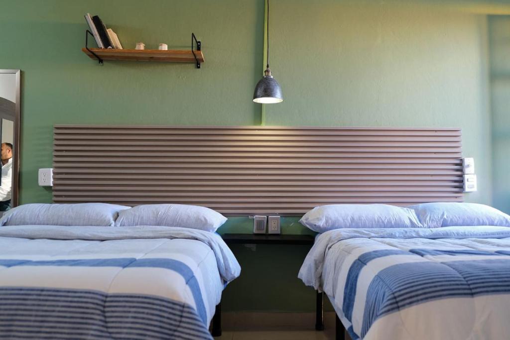 a room with three beds and avertisement at Remodeled Cozy Central 3 blocks from the Malecon in Mazatlán