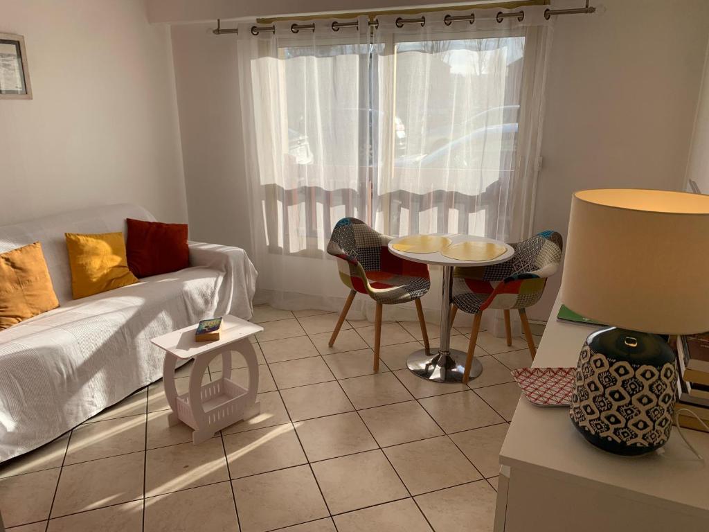 une chambre avec un lit, une table et des chaises dans l'établissement Edith, à Trouville-sur-Mer