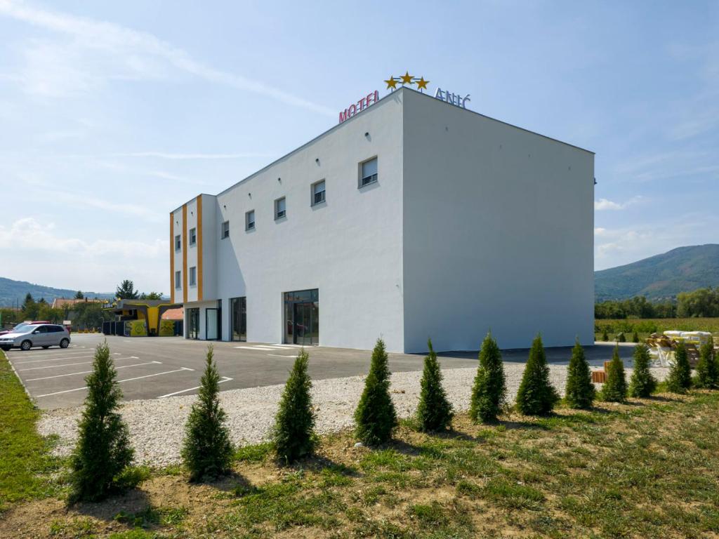 a building with a row of trees in front of it at Motel Anić in Novi Travnik