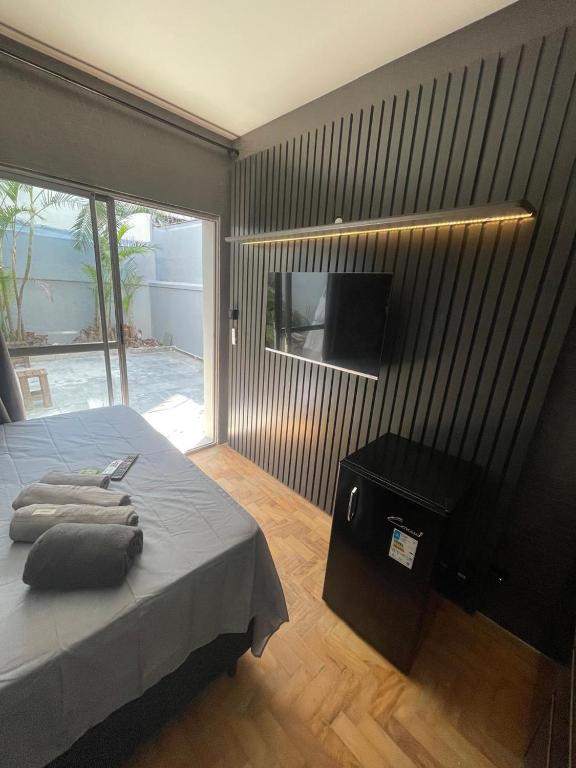 a bedroom with a bed and a wall with a television at Flats SP Vila Olímpia in Sao Paulo