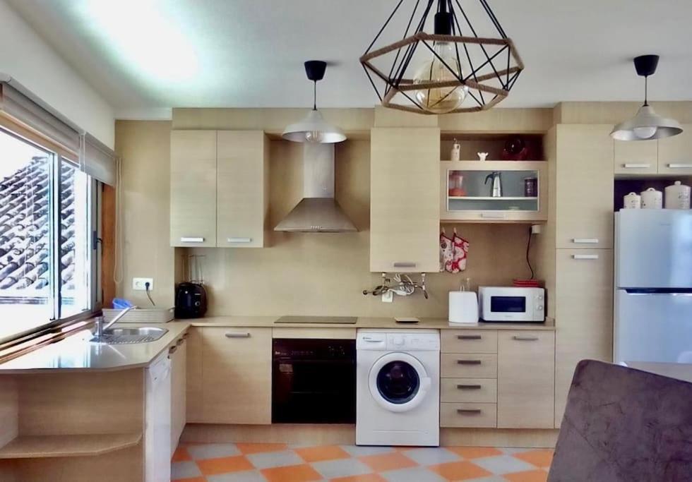a kitchen with a washer and a white refrigerator at Da Cañota1, Playas Vilariño, Hío y Aldán in Aldán