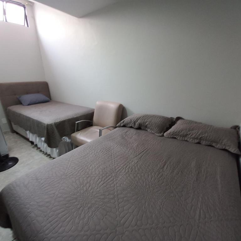 a bedroom with a bed and a chair at Apartamento 2 quartos Asa Norte com cozinha excelente localização in Brasilia