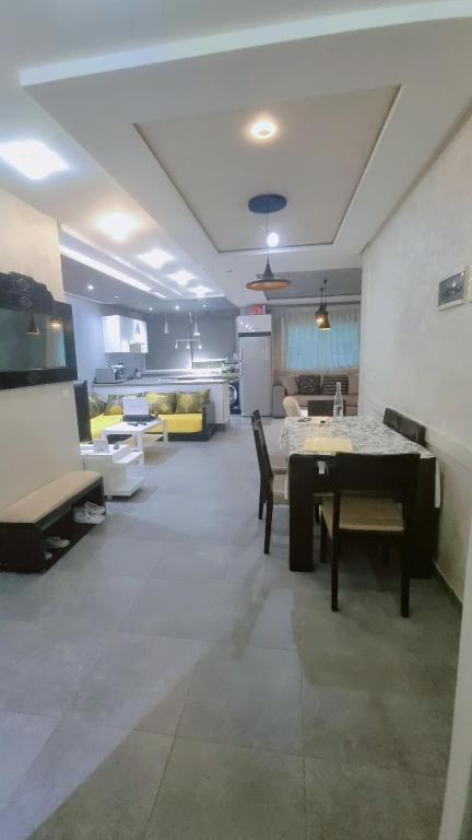 a living room with a table and a couch at Appartement meublé harhora in El Harhoura