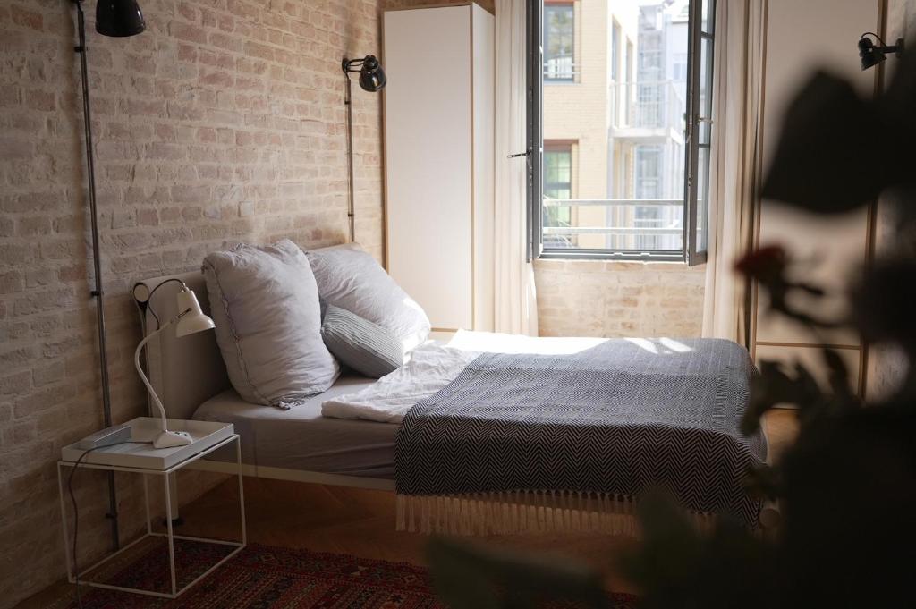 a bedroom with a bed and a window at Loft Studio in historic factory building in Berlin