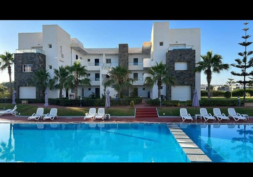 a large building with a swimming pool in front of a building at perla Saïdia in Saidia 
