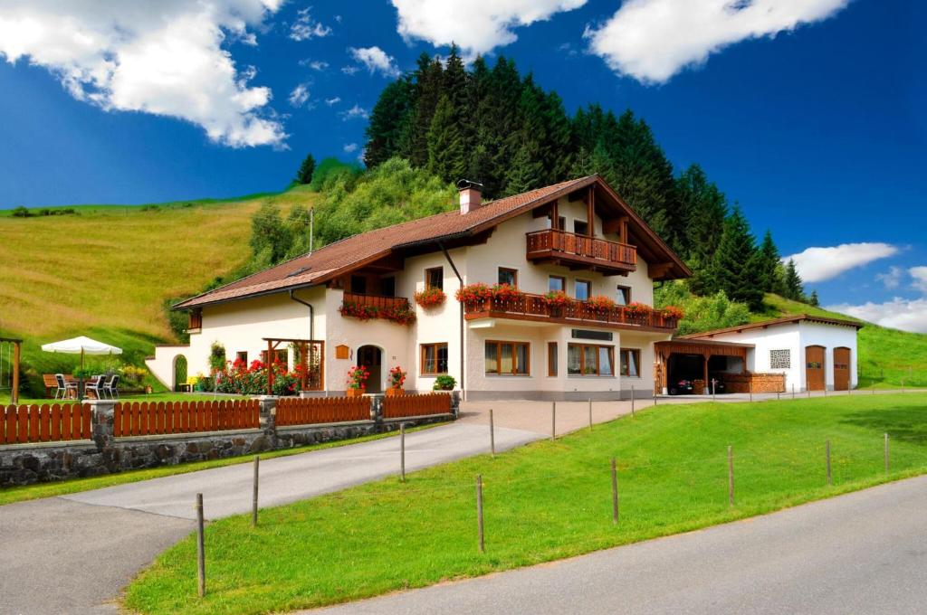 een huis op een heuvel met een groen veld bij Bergquell Tirol in Jungholz