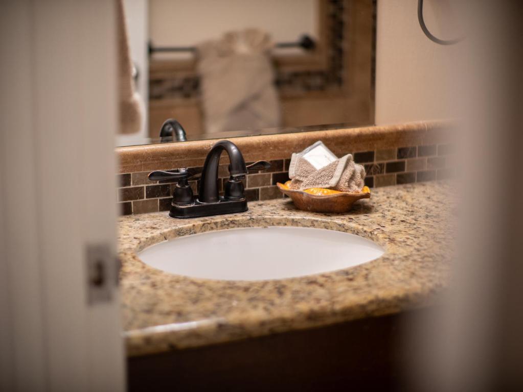 a bathroom counter with a sink and a mirror at WBH D116 Aloha Wai - Garden Suite Just Steps from the Sea in Kihei