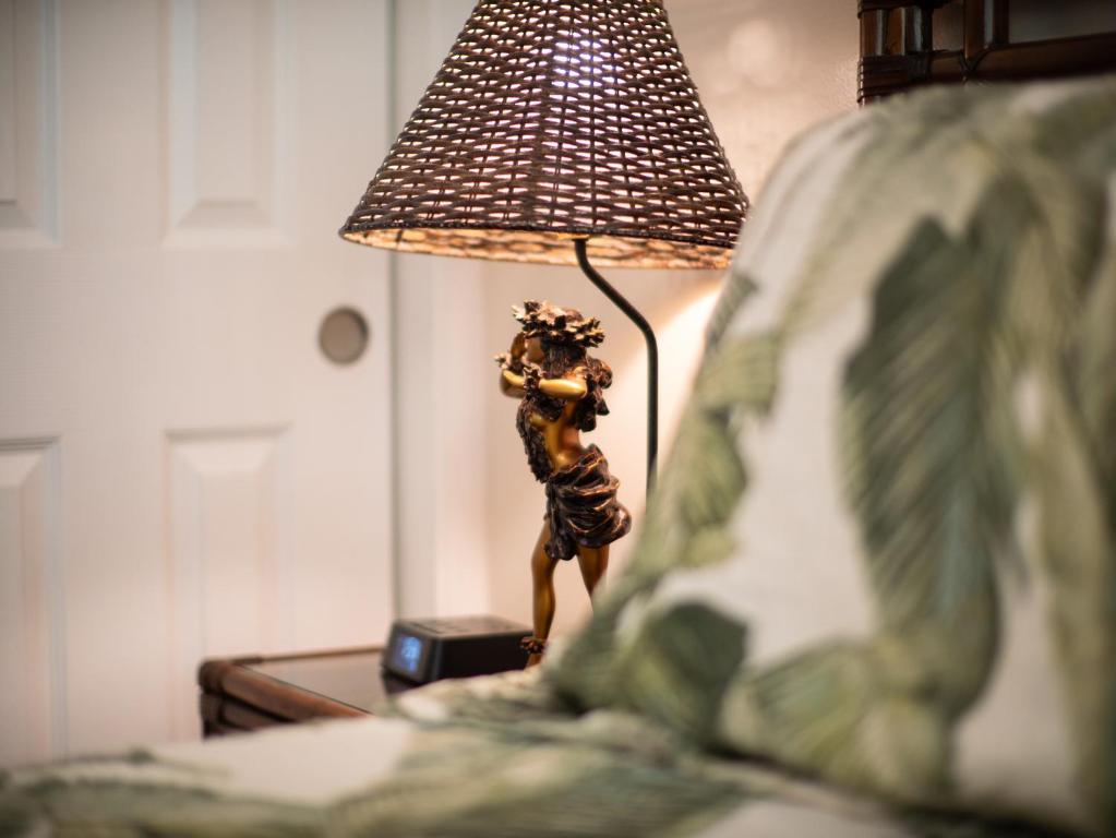 a lamp sitting on a table next to a bed at WBH D116 Aloha Wai - Garden Suite Just Steps from the Sea in Kihei