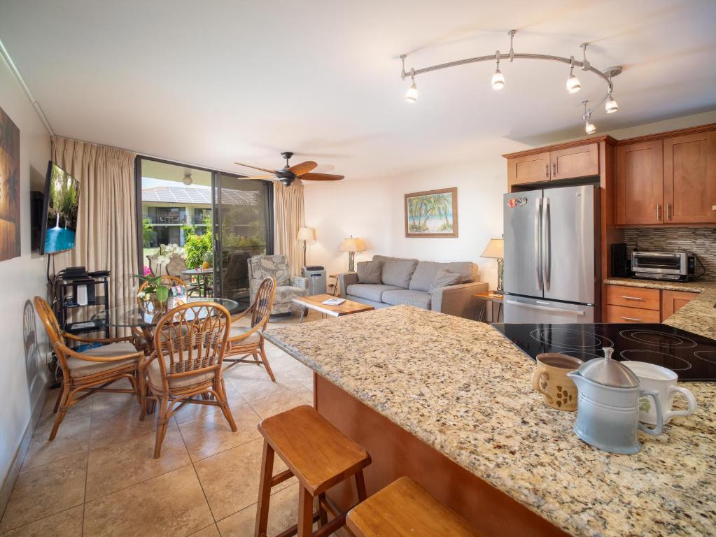 a kitchen and living room with a table and chairs at WBH D116 Aloha Wai - Garden Suite Just Steps from the Sea in Kihei