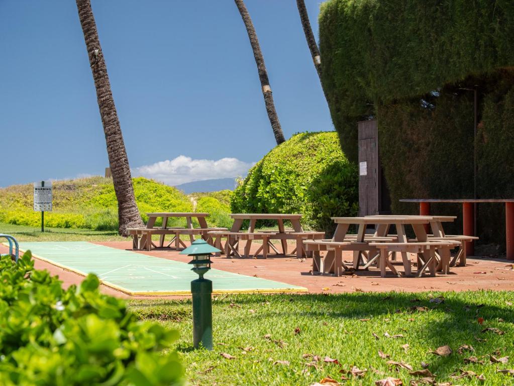 a group of picnic tables in a park at WBH D116 Aloha Wai - Garden Suite Just Steps from the Sea in Kihei