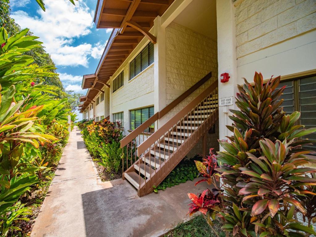 a building with stairs and plants in front of it at WBH D116 Aloha Wai - Garden Suite Just Steps from the Sea in Kihei