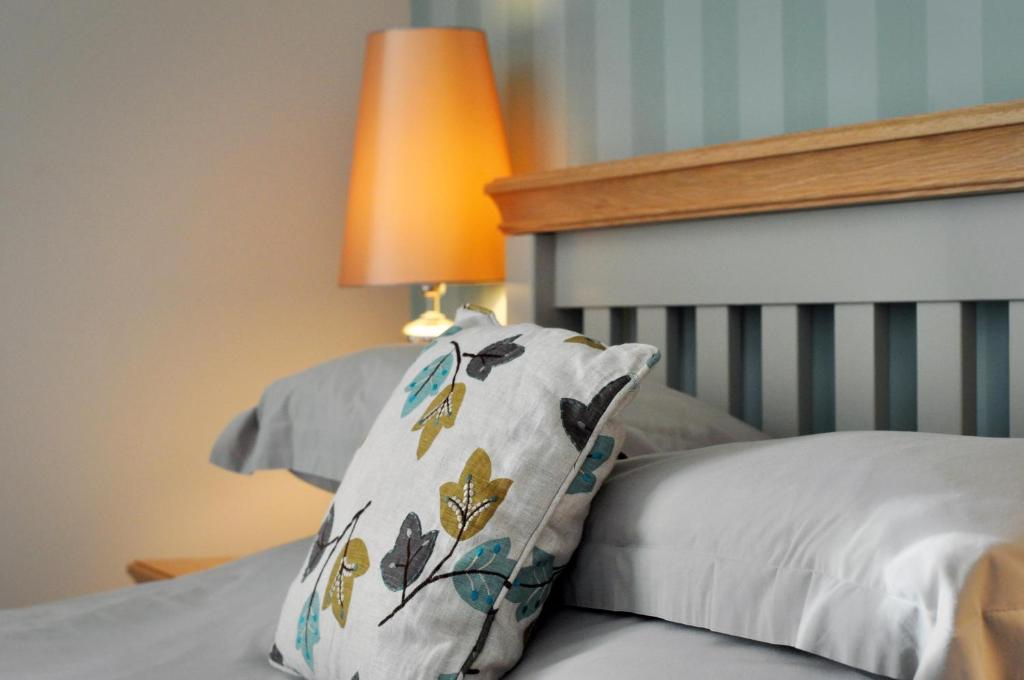 a pillow sitting on top of a bed with a lamp at Newport Links Golf Club , Pembrokeshire in Newport