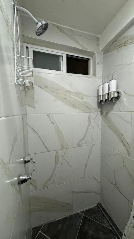 bagno con pareti in marmo bianco e finestra di Casa los Arcos Oaxaca a Città di Oaxaca