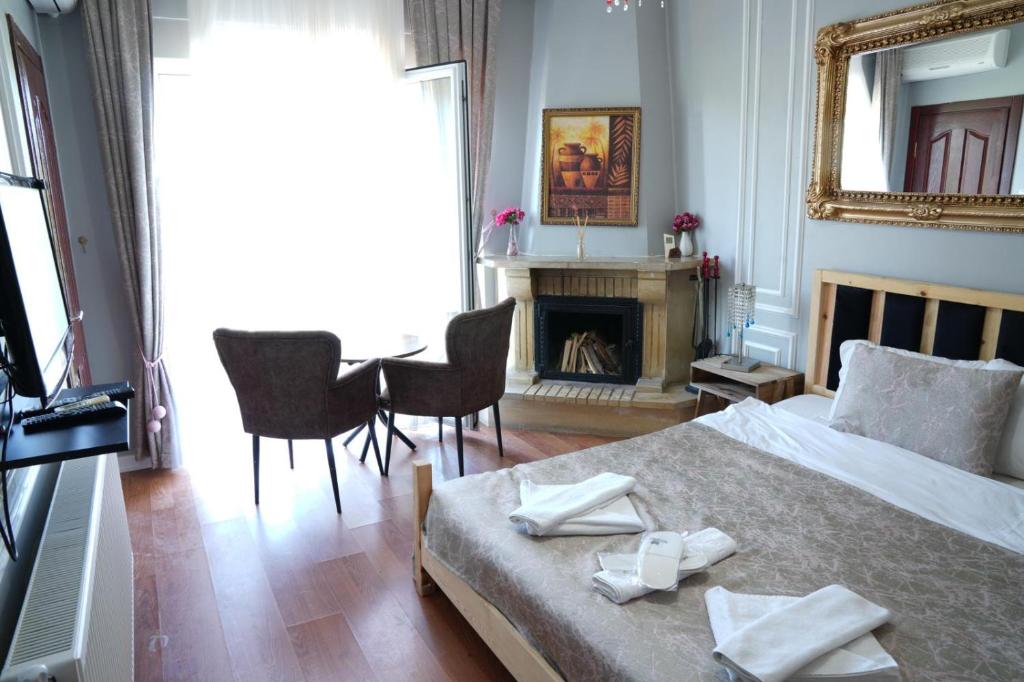 Schlafzimmer mit einem Bett, einem Tisch und einem Kamin in der Unterkunft BUTTERFLY BOUTIQUE HOTEL AĞVA in Sile