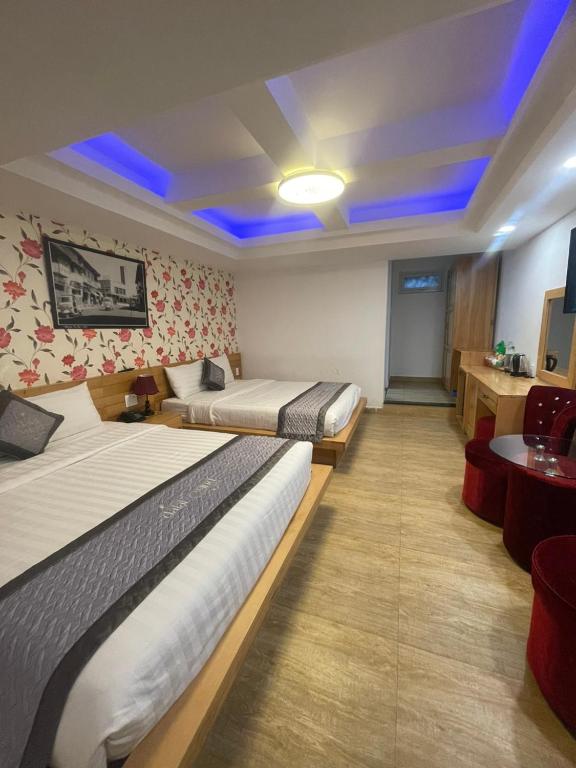 a hotel room with two beds and a table at Dalat Wind Hotel in Da Lat