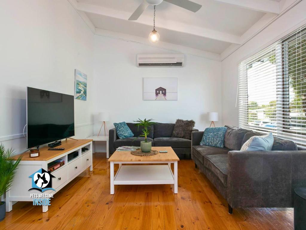 a living room with a couch and a flat screen tv at 3BR Updated Coastal Beach House in Funky Port Elliot in Port Elliot