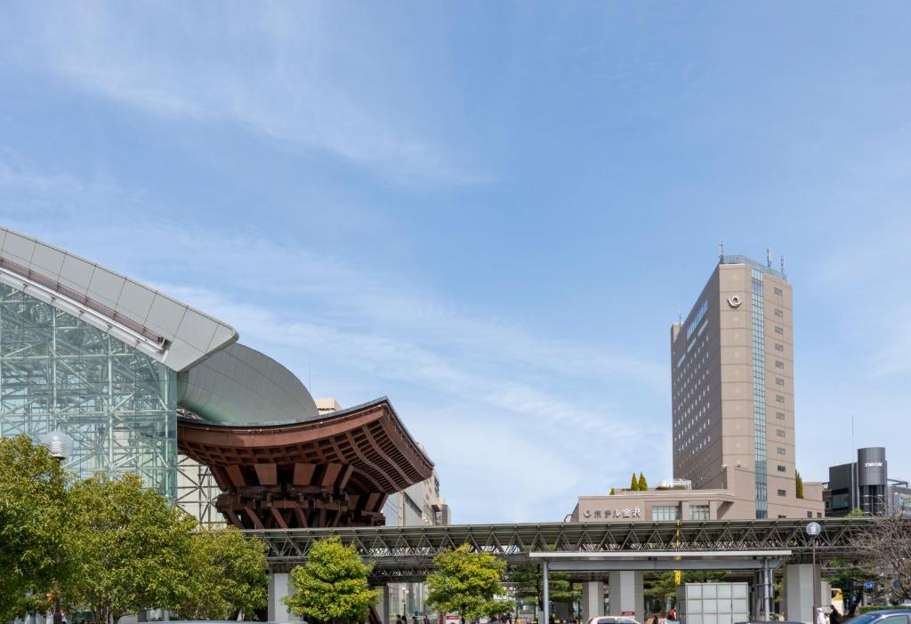 a building with a tall building in the background at Hotel Kanazawa in Kanazawa