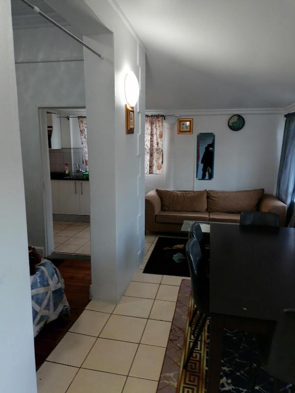 a living room with a couch and a table at 37 Grant prix lodge in Cape Town