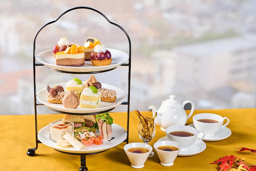 a three tiered tray of desserts and cups of tea at Hotel Kanazawa in Kanazawa