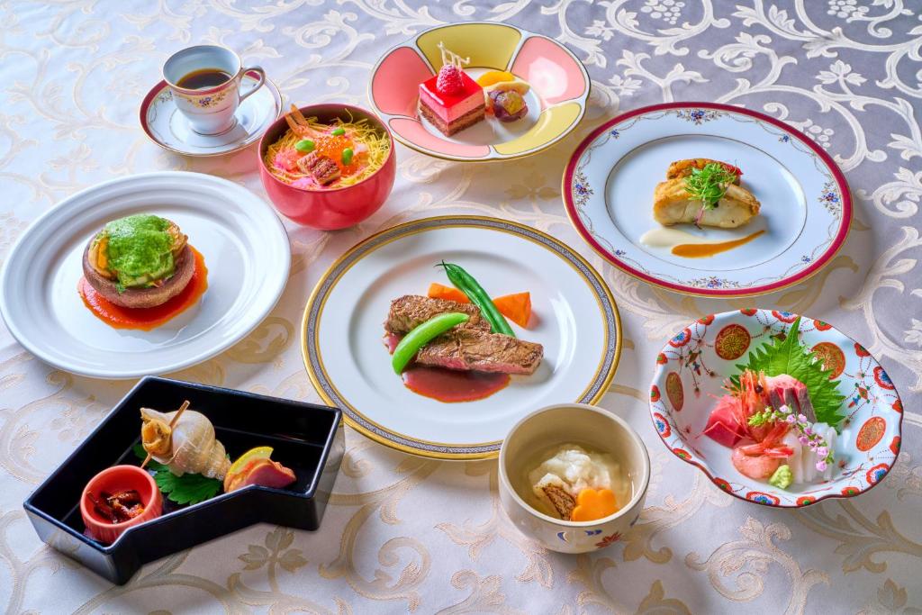 a table with plates of food and bowls of food at Hotel Kanazawa in Kanazawa