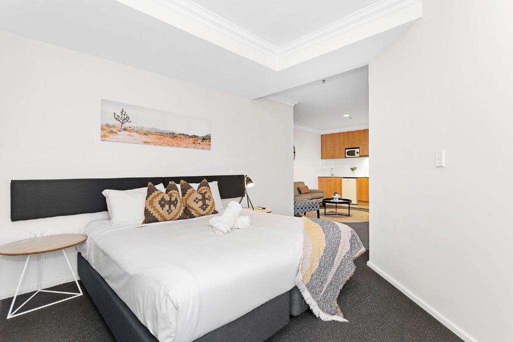 a bedroom with a white bed and a table at Perth's Premie King Deluxe in Perth