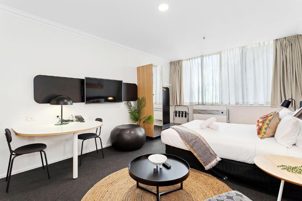 a hotel room with a king sized bed and a desk at Murray St Urban Retreat in Perth