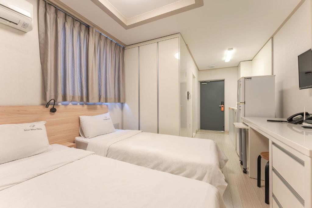 Postel nebo postele na pokoji v ubytování Staywell Hotel