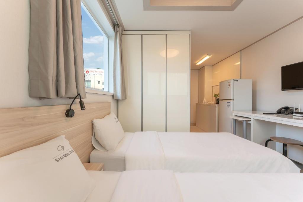 Postel nebo postele na pokoji v ubytování Staywell Hotel