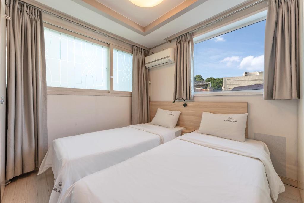 Postel nebo postele na pokoji v ubytování Staywell Hotel