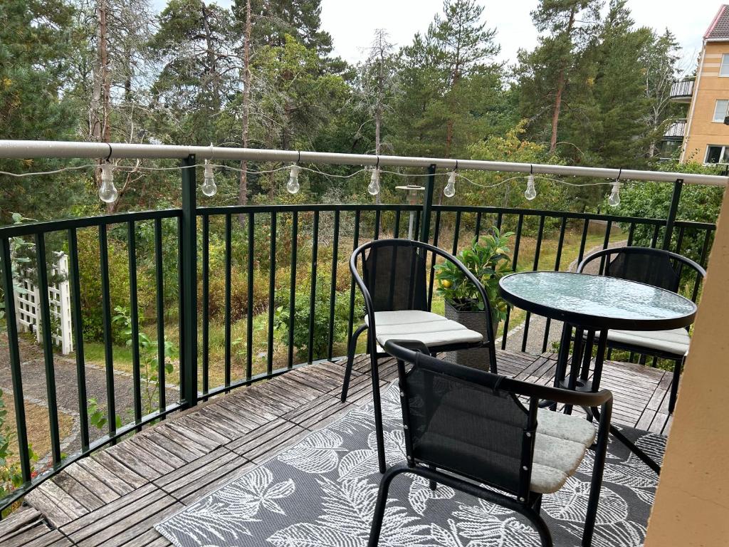 a balcony with two chairs and a table and a fence at Close2City in Nacka