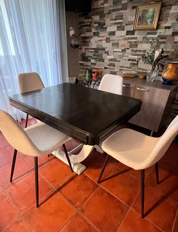 - une table à manger et des chaises noires dans la cuisine dans l'établissement Gîte de standing climatisé avec piscine, à Sainte-Cécile-les-Vignes