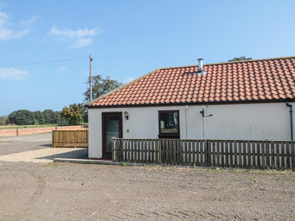 ein kleines weißes Gebäude mit rotem Dach in der Unterkunft Curlew Cottage in Filey