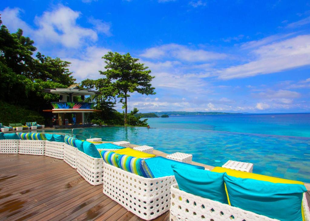 a pool with chairs and the ocean in the background at Fairways and Bluewater Boracay in Boracay