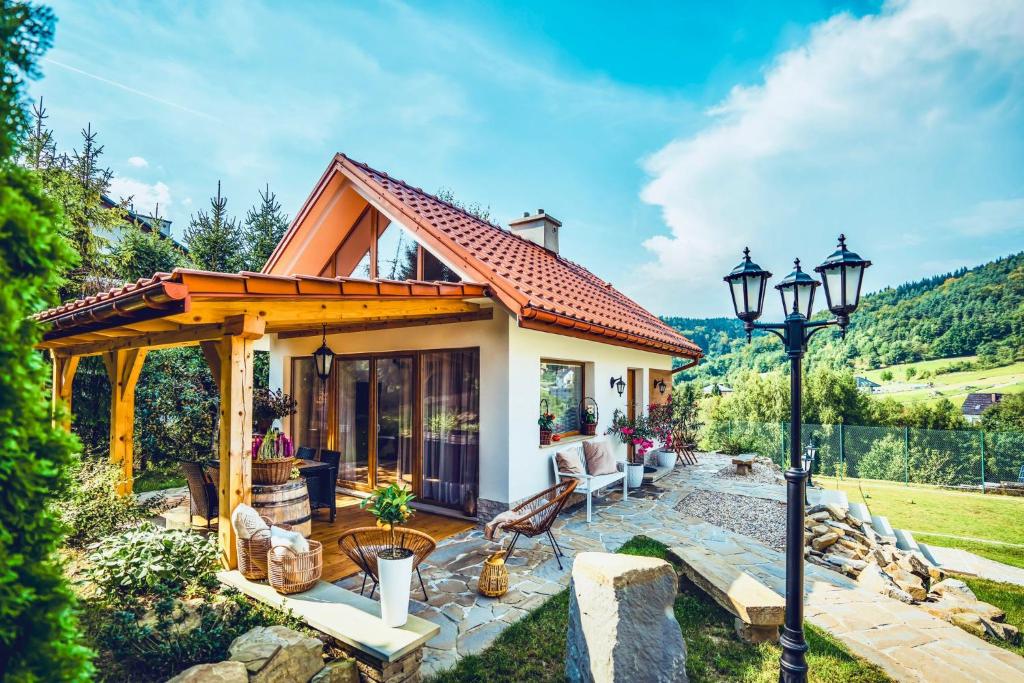 a small house with a patio and a street light at ForRest House Jacuzzi & Sauna in Jasienica