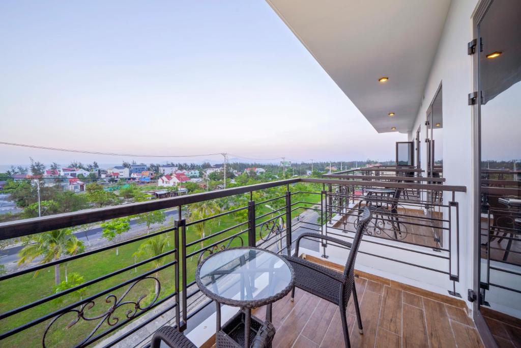 a balcony with a glass table and chairs at Athenia Hoi An Boutique Hotel & Spa in Hoi An