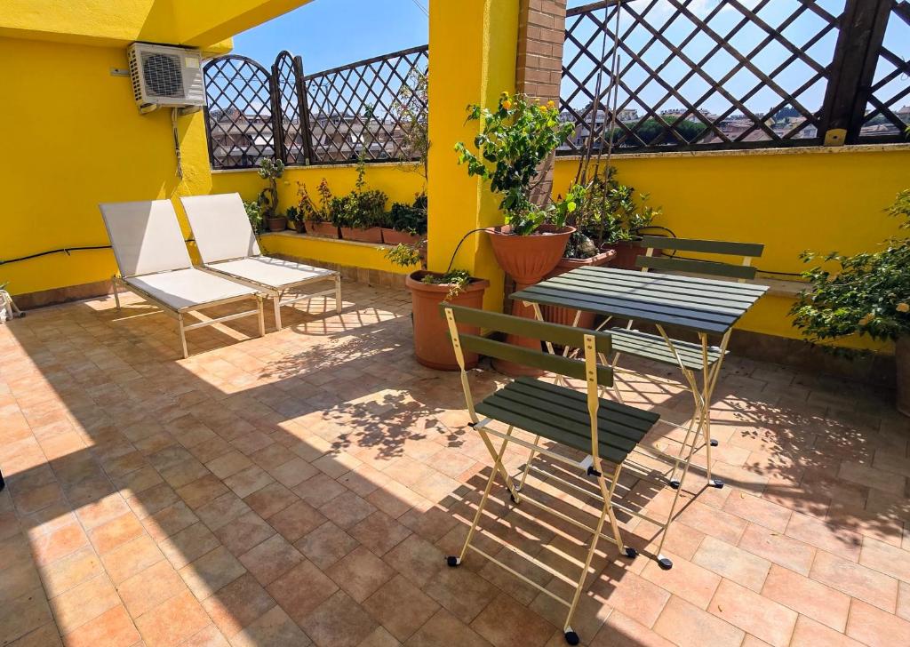 d'une terrasse avec 2 chaises et une table sur un mur jaune. dans l'établissement Un sacco di vento, à Marino
