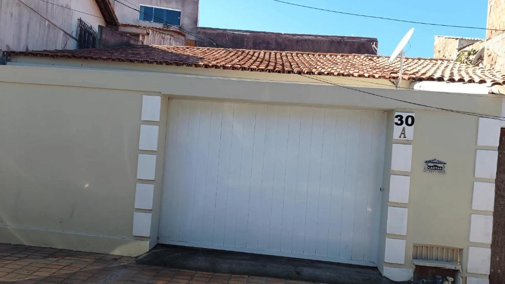 two white garage doors with the number on them at Casa - Praia dos Anjos - Arraial do Cabo - Aluguel Econômico in Arraial do Cabo
