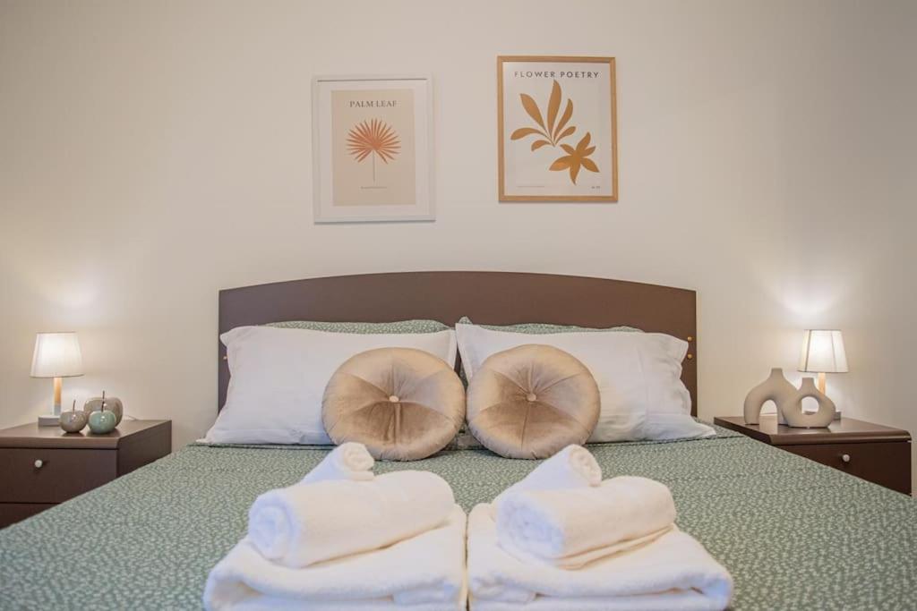 a bed with three towels on top of it at ApartExperience Nel cuore di Bra Comfort con Parcheggio privato in Bra