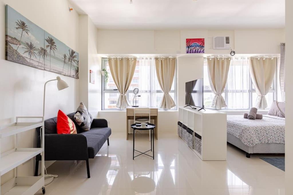 a bedroom with a bed and a couch in a room at Perfect accommodation for you in Levels Burbank in Manila