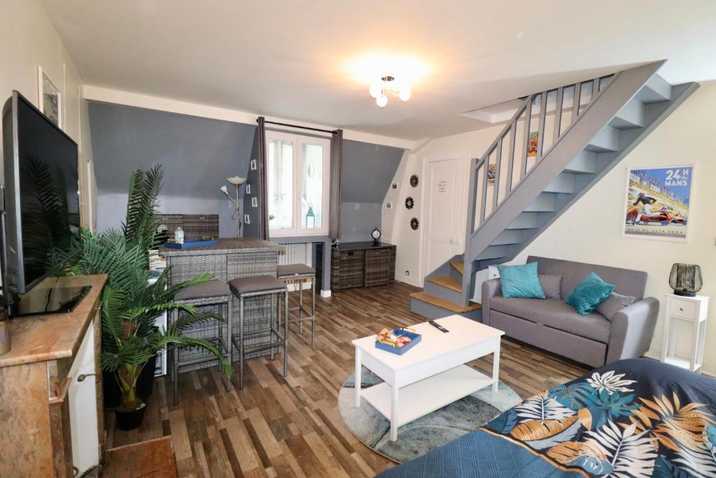 un salon avec un canapé et un escalier dans l'établissement Duplex au 2ème et de notre maison -Accès au jardin-Smart Tv-Streaming-Wifi, au Mans