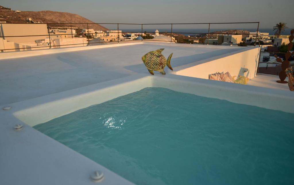 Una piscina con una estatua de un gato en el tejado. en Art Canava Luxury Villas, en Fira