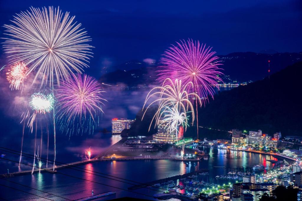 a firework display over a city at night at Chateraise Lodge Atami in Atami