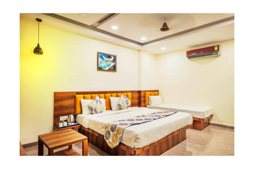 a bedroom with a large bed and a table at Hotel Dream Inn in Mānglia