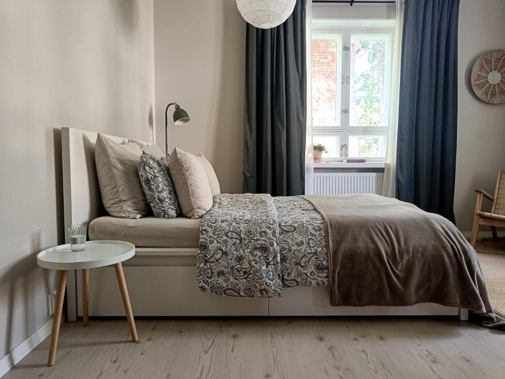 une chambre avec un lit, une table et une fenêtre dans l'établissement Tunnelmallinen yksiö kaupungin läheisyydessä, à Lahti