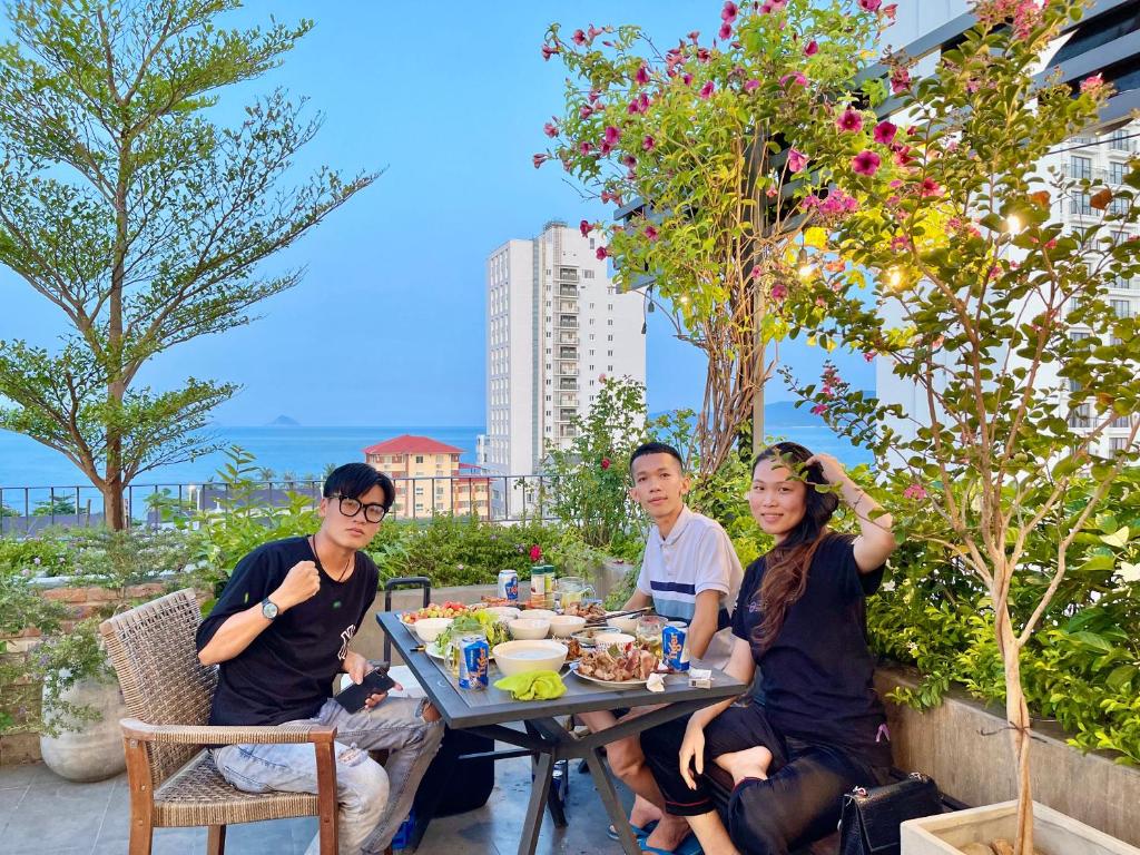 a group of people sitting at a table eating food at Coast House Boutique Hotel in Nha Trang