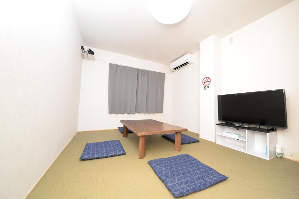sala de estar con mesa y TV de pantalla plana en ACT Residence No.1, en Tokio
