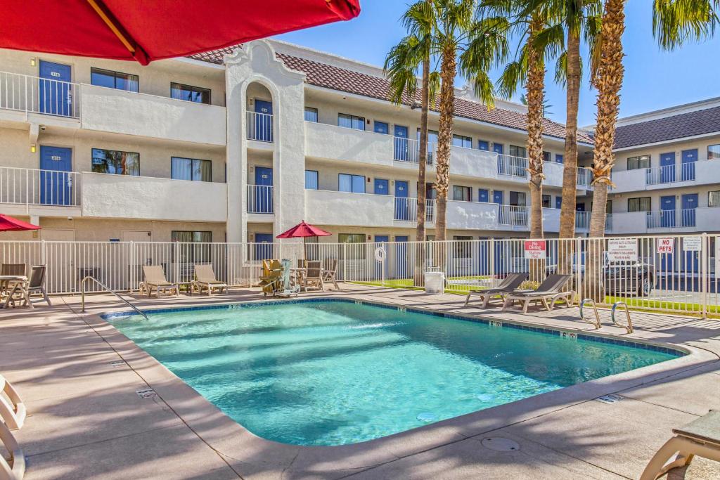 una piscina frente a un edificio con palmeras en Motel 6-Phoenix, AZ - West, en Phoenix