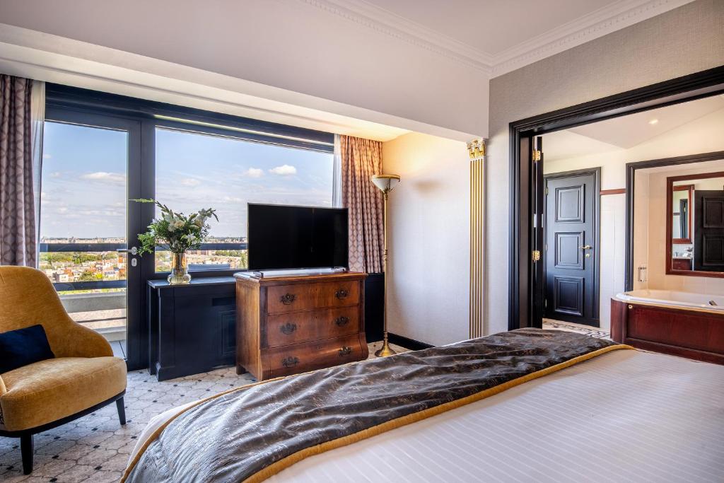 a bedroom with a bed and a tv and a window at Hotel Barsey by Warwick in Brussels