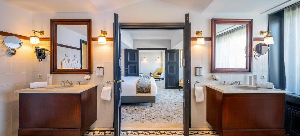 a bathroom with two sinks and a bedroom at Hotel Barsey by Warwick in Brussels